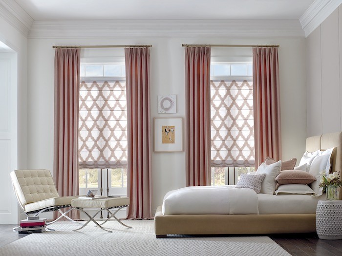A bedroom with rose colored window coverings